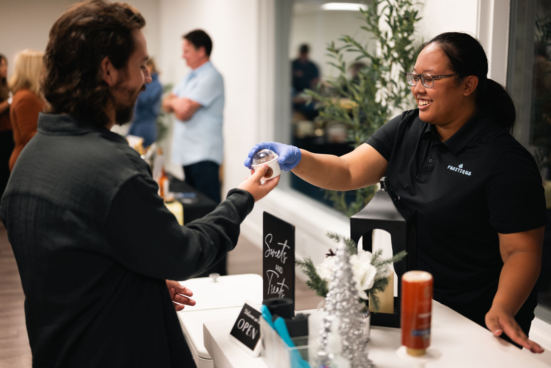 Dessert vendor handing a treat to a guest at an event at Granite City Workspaces in Folsom