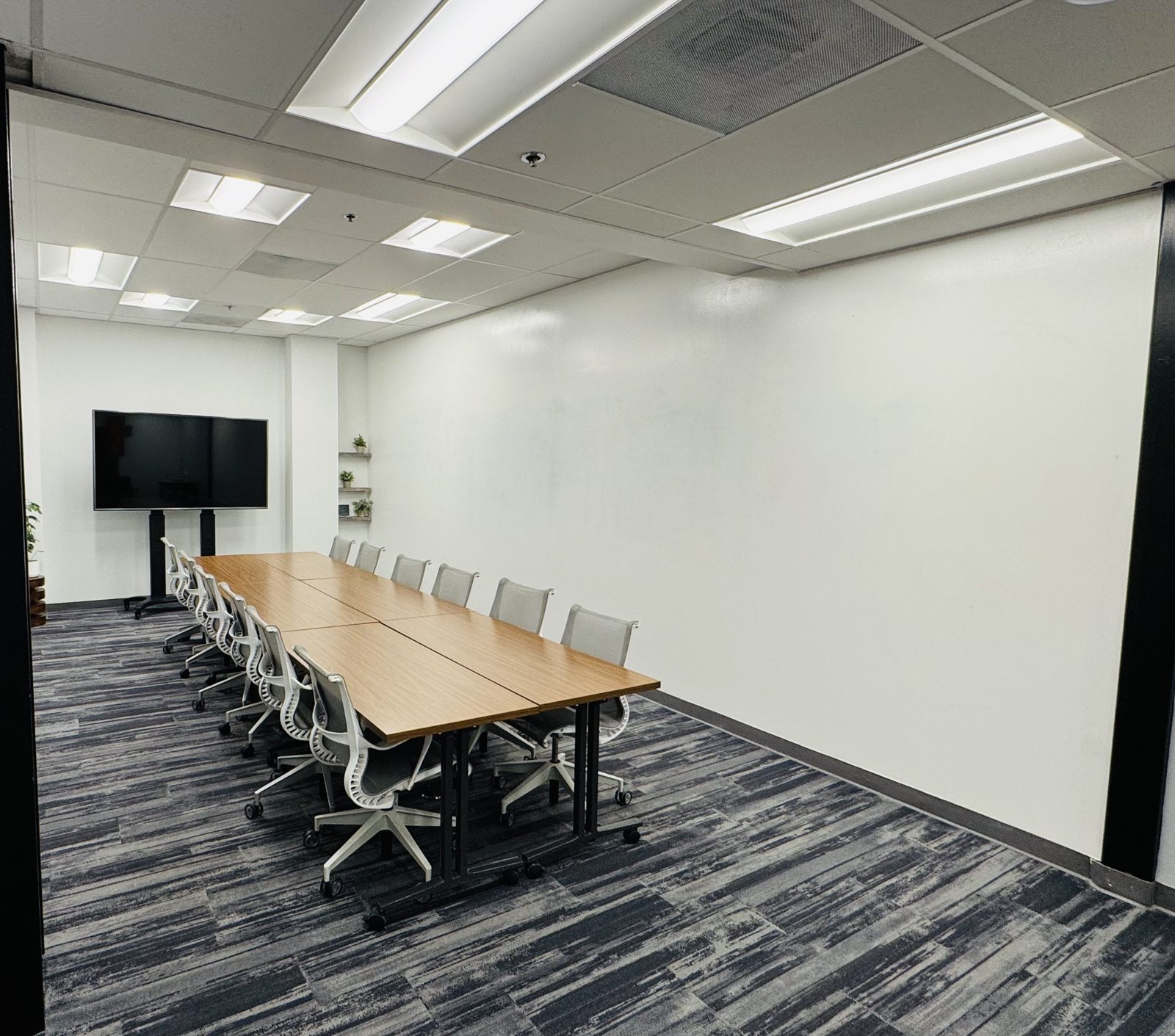 Town Hall meeting room at Granite City Workspaces with boardroom table and display